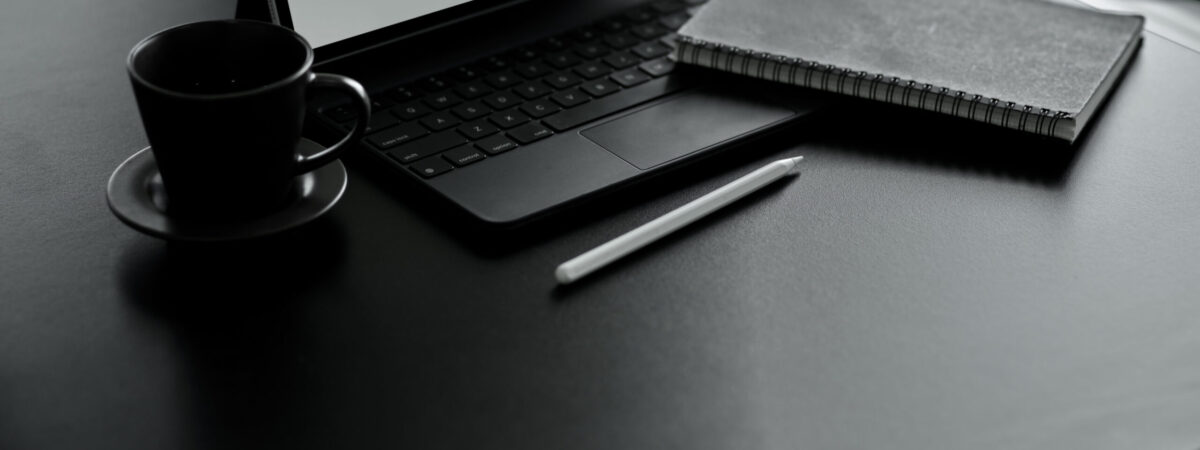 Close up view of worktable with digital tablet, keyboard, stylus, supplies and copy space